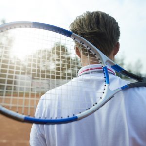 Man is holding a tennis racket