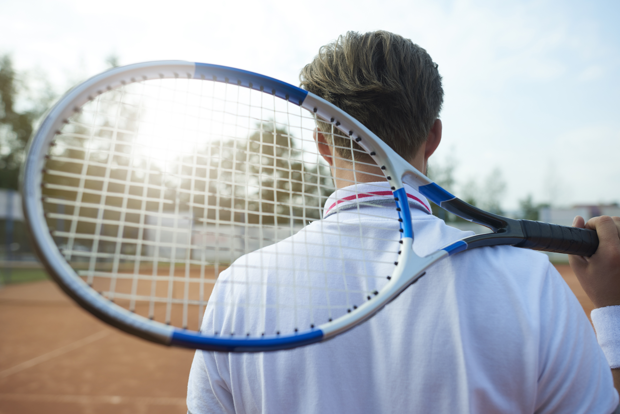 Man is holding a tennis racket